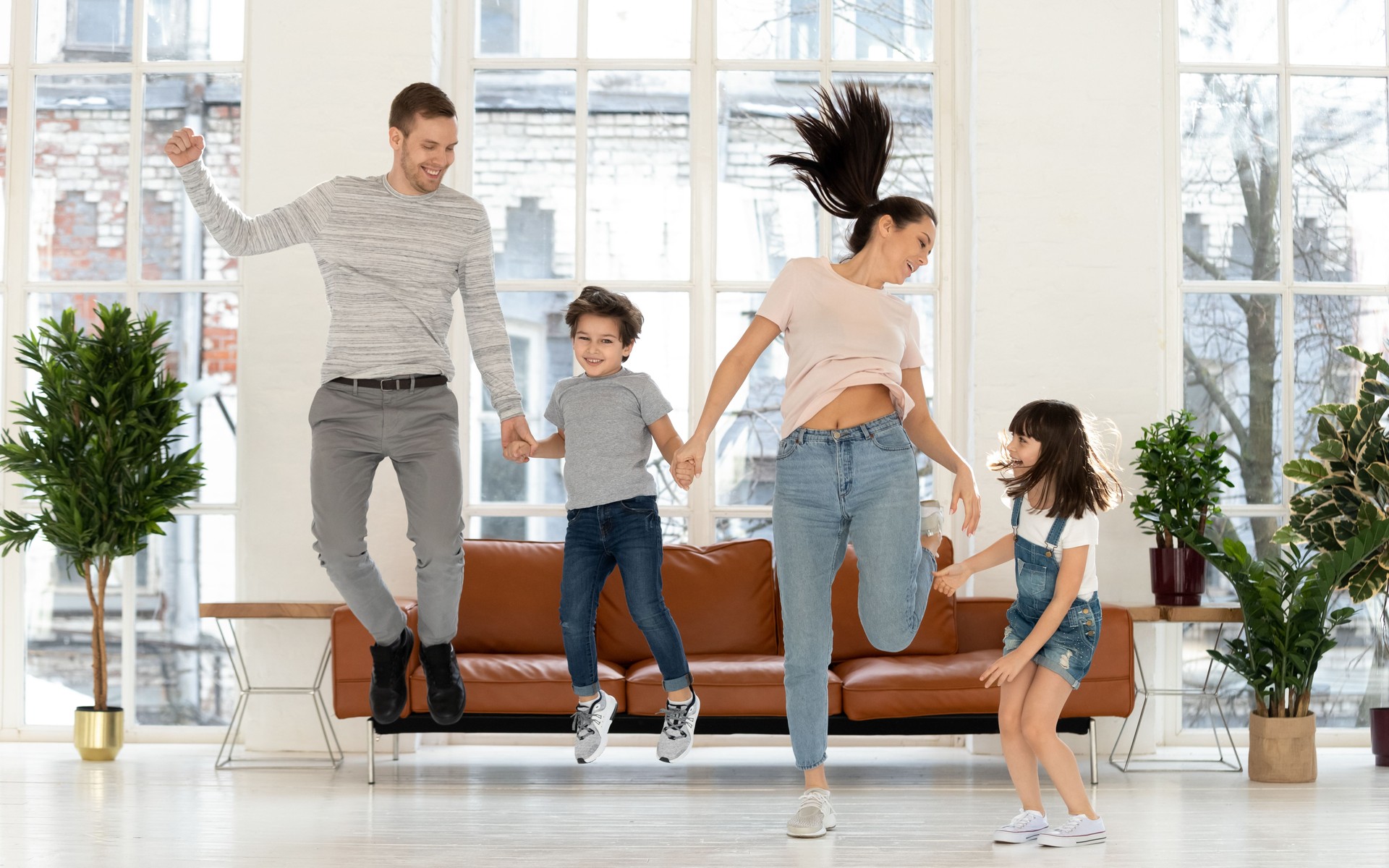 Happy parents have fun jumping together with kids